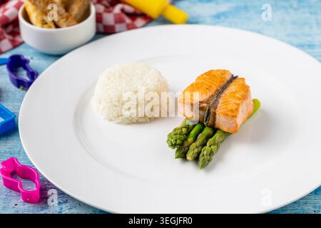 Salmone grigliato con riso e asparagi su un piatto bianco minimo Foto Stock