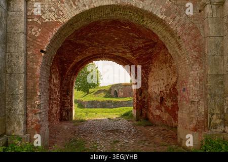 Primo piano di mattoni e archi di pietra nelle rovine della fortezza storica. Foto Stock