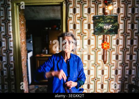 Donna anziana, pernottamento e colazione. Nel 1978 doveva ancora usare una lampada a gas. Visto qui c'è un piccolo dipinto del suo cottage. Agriturismo interno Cornovaglia Baldhu, Chacewater, Cornovaglia, Inghilterra Regno Unito 1970s HOMER SYKES Foto Stock