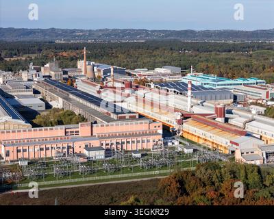 Il drone cattura un'area industriale con fabbriche e infrastrutture in un ambiente rurale in una giornata limpida. Foto Stock