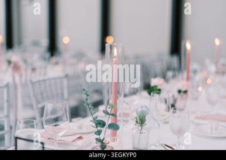 Ambiente elegante con candele e fiori. Raffinata atmosfera serale con illuminazione e arredamento soffici Foto Stock