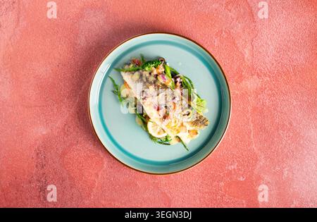 Pesce deliziosamente placcato con verdure vivaci su uno sfondo artistico Foto Stock