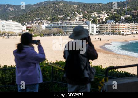 Visitatori che si affacciano sulla spiaggia di Platja Gran a Tossa de Mar, una città costiera situata sulla Costa Brava in Catalogna, Spagna Foto Stock