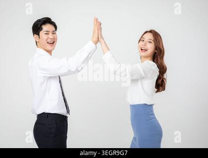 Due giovani professionisti, un uomo e una donna, cinque in alto l'un l'altro con un grande sorriso. Foto Stock