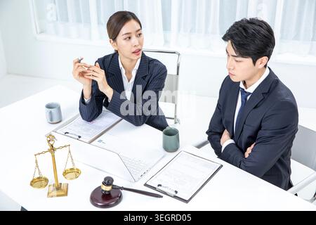 Due colleghi che discutono di un documento in un ufficio moderno. Foto Stock