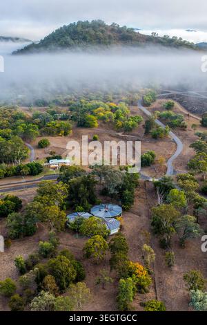 Vista verticale dall'alto della parete della diga di Glenbawn e del paesaggio circostante con la nebbia che attraversa la valle nel nuovo Galles del Sud dell'Australia. Fotografia con i droni Foto Stock
