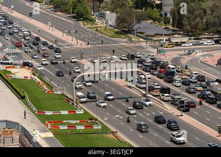 Veduta aerea di un trafficato incrocio stradale a più corsie con traffico intenso, veicoli e paesaggio verde sotto la luce del giorno a Dubai, Dubai, United Arab Foto Stock