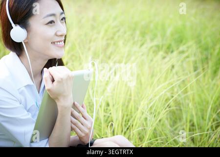 Sorridente imprenditrice ascolto di musica Foto Stock