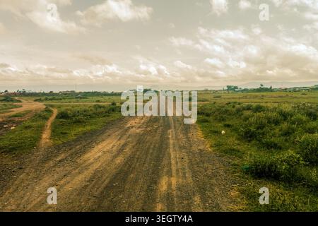 Rough Dirt Road che attraversa il paesaggio rurale tra praterie di Savannah vicino a Suswa Town, Kenya Foto Stock