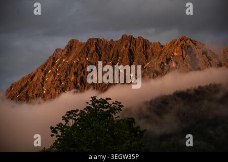 Osserva la grandiosità mozzafiato delle Alpi mentre una spettacolare catena montuosa è baciata dalla luce dorata del tramonto. Questa straordinaria foto di scorta cattura Foto Stock