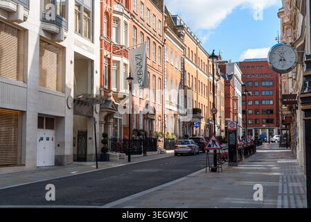 Londra, Regno Unito - 27 agosto 2023: Una giornata di sole a Londra, con una strada costeggiata da edifici classici e un orologio. Foto Stock