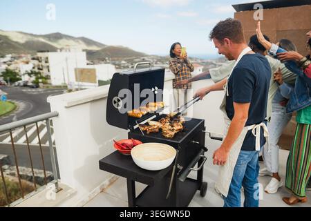 Famiglia persone che si divertono al barbecue pranzo domenicale - gruppo di amici che fanno foto insieme - concetto di cibo, amicizia e stile di vita estivo Foto Stock