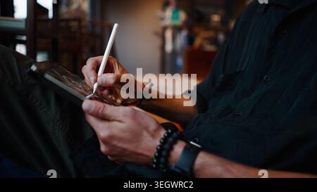 Persona che utilizza un tablet digitale e uno stilo per l'arte creativa e il design Foto Stock