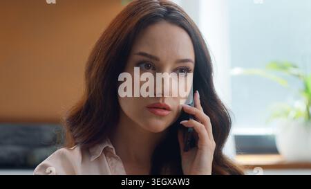 Ritratto infelice irritato preoccupato donna caucasica serio parlare telefono cellulare discutere problema a casa. Donna d'affari donna d'affari parla di preoccupazione Foto Stock