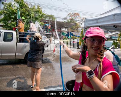 La gente celebra il festival di Songkran a Lampang, in Thailandia, con una vivace lotta sull'acqua in una giornata di sole. Foto Stock