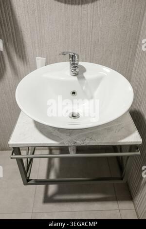 Lavandino in ceramica bianca del bagno con rubinetto cromato Foto Stock