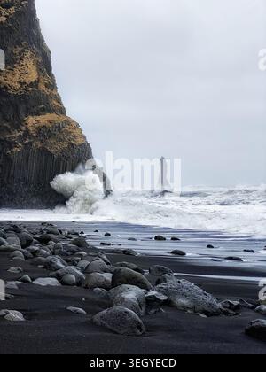 Impressionante vista della spiaggia di Black Sand e delle strutture verticali di lava vulcanica sulla costa dell'Islanda durante la tempesta invernale Foto Stock