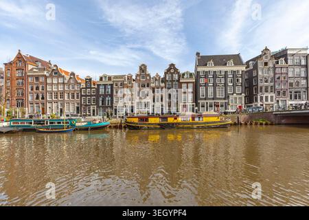 Chiatte ormeggiate sul canale di fronte alle case tradizionali, Singel, Amsterdam Foto Stock