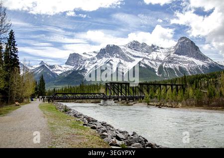 Storico Canmore Engine Bridge sul fiume Bow con montagne innevate, Alberta, Canada Foto Stock