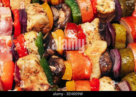 Spiedini di carne e verdura grigliati in primo piano sul barbecue. Preparazione dei pasti fatti in casa all'aperto e concetto di cucina tradizionale. Foto Stock