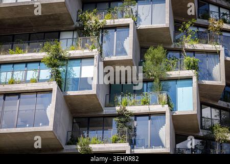 Vista di un moderno edificio residenziale caratterizzato da balconi in cemento a sbalzo con lussureggiante vegetazione verde e grandi finestre in vetro a Quito, Pichincha Foto Stock