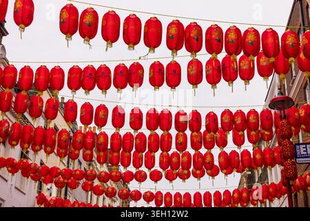 Londra, Regno Unito - 12 maggio 2025: Veduta delle lanterne rosse cinesi appese in fila di fronte a una strada di Chinatown sotto un cielo coperto. Foto Stock