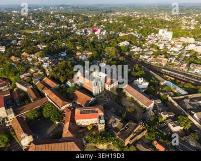 Vista aerea della Cattedrale di St. Mary circondata da edifici dal tetto rosso e lussureggiante vegetazione tropicale sotto la luce del sole dorato a Galle, nella Provincia meridionale, S. Foto Stock