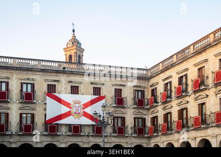 VITORIA-GASTEIZ, SPAGNA - AGOSTO 2025: La dettagliata architettura neoclassica del municipio in Plaza Nueva (Plaza de España) con il suo orologio iconico Foto Stock