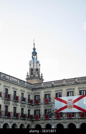 VITORIA-GASTEIZ, SPAGNA - AGOSTO 2025: La dettagliata architettura neoclassica del municipio in Plaza Nueva (Plaza de España) con il suo orologio iconico Foto Stock
