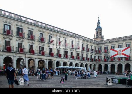 VITORIA-GASTEIZ, SPAGNA - AGOSTO 2025: La dettagliata architettura neoclassica del municipio in Plaza Nueva (Plaza de España) con il suo orologio iconico Foto Stock