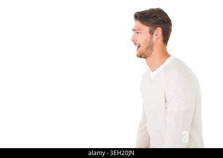 Uomo che parla in uno studio a destra, indossa un pullover beige e una camicia girocollo bianca, copia spazio Foto Stock