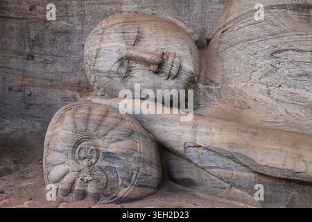 Primo piano dell'immagine scolpita sdraiata del Buddha a Gal Vihara, un tempio buddista a Polonnaruwa, Sri Lanka. La testa poggia su un cuscino o su un'imbottitura Foto Stock