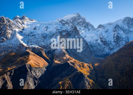Picco la Meije nel Parco Nazionale degli Ecrins, Alpi francesi. Montagne innevate e foreste di larici dorati nelle Hautes-Alpes, Francia Foto Stock