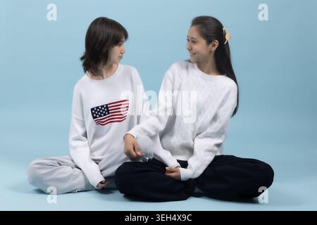 Due giovani donne sedute a terra Foto Stock