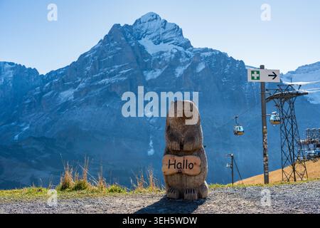 Cartello di saluto con scultura di marmotte in legno e sfondo del monte Wetterhorn. Prima Grindelwald. Grindelwald, Cantone di Berna, Svizzera. Foto Stock