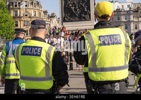 Londra, Regno Unito. 22 maggio 2026, gli agenti della polizia metropolitana esaminano i tifosi di Middlesbrough riuniti a Trafalgar Square, nel centro di Londra, in vista della finale di play-off del campionato EFL 2026 contro Hull City allo stadio di Wembley il giorno seguente. Gli agenti in abbigliamento ad alta visibilità monitorano gli arrivi anticipati mentre i tifosi iniziano a riempire la piazza al sole del pomeriggio prima delle celebrazioni pre-partita Credit:xiu bao/Alamy Live News Foto Stock