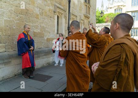 Oxford, Regno Unito. 22 maggio 2026. Dimostrando la diversità dell'apporto studentesco dell'Università di Oxford, un gruppo di monaci buddisti di Wimbledon, rivestiti di zafferano, scatta fotografie del loro collega nel suo abito di laurea in Radcliffe Square. Crediti: Anna Watson/Alamy Live News Foto Stock