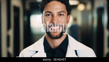 Ritratto, uomo e medico in ospedale con sorriso, conoscenza ed esperienza per il servizio sanitario. Felice, persona maschile e operatore medico in clinica con Foto Stock