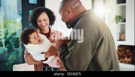 Felice, genitori e giocare con il bambino a casa, ridere e legarsi con la ragazza nel fine settimana e in connessione. Gli africani, mamma e papà con la figlia, sorridono Foto Stock