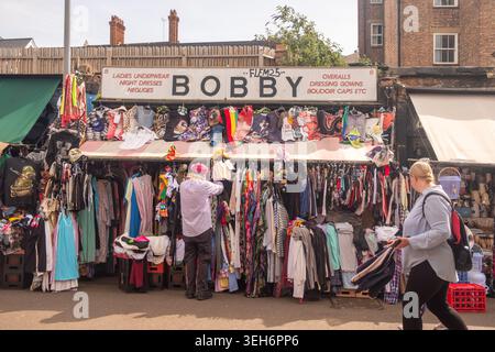 LONDRA - 9 APRILE 2026: SHEPHERDS BUSH MARKET - Bobby Clothing stall with trader Foto Stock