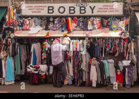 LONDRA - 9 APRILE 2026: SHEPHERDS BUSH MARKET - Bobby Clothing stall with trader Foto Stock