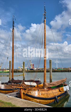 Den Oever, Paesi Bassi - 18 maggio 2026: Vista delle storiche navi a vela Wieringeraak attraccate nel porto di pesca sotto un cielo blu nuvoloso con un vento Foto Stock