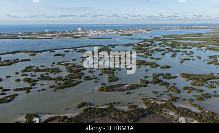 Vista aerea della laguna di Yucalpeten con numerose isole di mangrovie e lo skyline della città in lontananza sotto un cielo limpido Progreso, Yucatan, Messico. Foto Stock