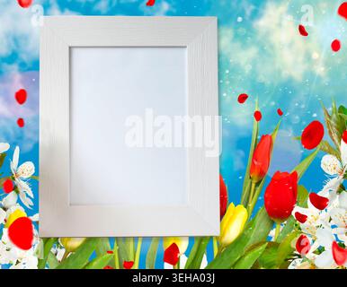 Еmpty modello di mockup con cornice bianca. Cornice fotografica vuota su uno sfondo natalizio con fiori di tulipani rossi e gialli colorati Foto Stock
