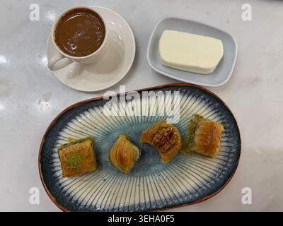 Caffè turco, pasticceria baklava assortita servita con gelato dondurma su un piatto decorativo in ceramica, tavolo in marmo nel caffè. Cucina, menu di dessert Foto Stock