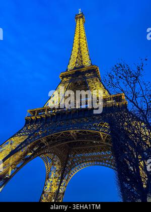 Torre Eiffel illuminata all'ora blu vista dal basso a Parigi, Francia. Foto Stock