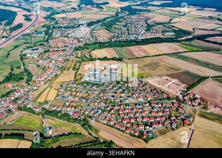 Vista aerea della città di Schlusselfeld con case dal tetto rosso, edifici industriali e campi agricoli verdi e dorati circostanti Schlu Foto Stock