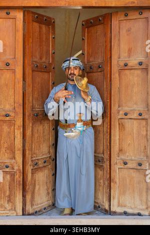Un interprete di al-Razha (danza guerriera energica e ritmica) in tradizionale abbigliamento Oman con spada e scudo presso la Fortezza Nizwa a Nizwa, Oman Foto Stock