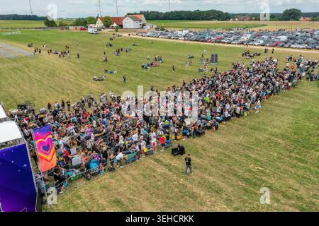 Herzogenaurach, Germania - 25 luglio 2025: Veduta aerea dell'ingresso all'Open Beatz Festival con una grande folla di persone in coda su un campo verde accanto Foto Stock
