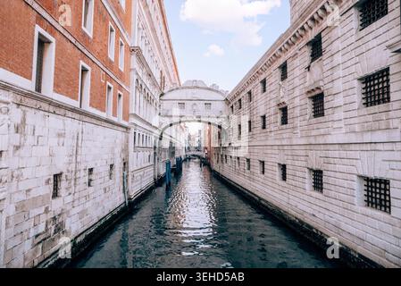 Storico Ponte dei Sospiri di Venezia illuminato dalla luce soffusa del mattino sopra il tranquillo canale. L'iconica architettura veneziana e l'atmosfera tranquilla catturano la bellezza senza tempo della città italiana. Foto Stock